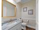 Close-up of powder room featuring a marble vanity, decorative wallpaper and gold mirror at 1105 Tazwell Pl, Raleigh, NC 27612