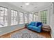 Bright sunroom with hardwood floors, large windows, and a comfortable blue love seat at 1105 Tazwell Pl, Raleigh, NC 27612