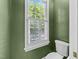 Picture of a modern low-flow toilet beside a window with white shutters and green walls at 1105 Tazwell Pl, Raleigh, NC 27612