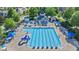 Aerial view of a large community pool with lounge chairs, umbrellas, and a water slide on a sunny day at 1109 Hemby Ridge Ln, Morrisville, NC 27560