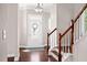 Inviting foyer view featuring hardwood floors, a staircase with white risers, and a decorative floral wreath on the door at 1109 Hemby Ridge Ln, Morrisville, NC 27560