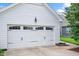 Garage featuring traditional carriage doors with decorative hardware and an exterior lamp at 1109 Hemby Ridge Ln, Morrisville, NC 27560
