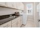 Functional laundry room with sink, granite countertop, storage cabinets and modern appliances at 1109 Hemby Ridge Ln, Morrisville, NC 27560