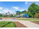 Community playground with a slide, swings, and picnic tables surrounded by green grass at 1109 Hemby Ridge Ln, Morrisville, NC 27560