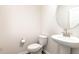 Powder room featuring a pedestal sink, a round mirror, and a modern toilet at 1113 Umstead Grove Way, Durham, NC 27712