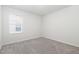 Minimalist bedroom with soft carpet, a window, and white walls, offering a bright and airy feel at 1113 Umstead Grove Way, Durham, NC 27712