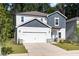Charming two-story home featuring a 2-car garage, white siding and a welcoming, covered entryway at 1113 Umstead Grove Way, Durham, NC 27712