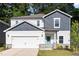 Charming two-story home featuring a 2-car garage, white siding and a delightful, turquoise front door at 1113 Umstead Grove Way, Durham, NC 27712
