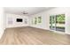 Bright living room with wood-look floors, a ceiling fan, and sliding glass doors to the backyard at 1113 Umstead Grove Way, Durham, NC 27712