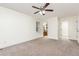 Neutral bedroom featuring a ceiling fan with adjacent bathroom and closet doors at 112 Avent Pines Ln, Holly Springs, NC 27540