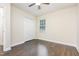 Cozy bedroom featuring hardwood floors, closet, and a bright window at 112 Avent Pines Ln, Holly Springs, NC 27540