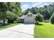 Charming home with a two-car garage, a well-maintained lawn, and mature landscaping at 112 Avent Pines Ln, Holly Springs, NC 27540