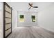 Bright bedroom with modern ceiling fan, natural light, and sliding barn door at 113 Pueblo Dr, Louisburg, NC 27549