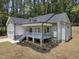 Charming home featuring a covered porch, stone accents, and lush landscaping, blending elegance with a touch of nature at 113 Pueblo Dr, Louisburg, NC 27549