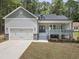 Desirable home boasts an attached garage, a porch, and meticulous landscaping at 113 Pueblo Dr, Louisburg, NC 27549