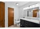 Elegant bathroom featuring a wood door, sleek vanity, marble countertop, and illuminated mirror at 113 Twisted Oak Pl, Durham, NC 27705