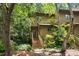 Charming townhouse with wood siding, lush landscaping, and inviting wooden staircase at 113 Twisted Oak Pl, Durham, NC 27705