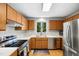 Bright kitchen boasts stainless steel appliances, wood cabinets, and sleek countertops at 113 Twisted Oak Pl, Durham, NC 27705