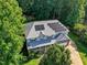 Aerial view of a house with solar panels and mature surrounding trees at 1205 Magnolia Hill Rd, Garner, NC 27529