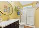 Bathroom with a vanity, toilet, and stand up shower with glass doors and bright yellow walls at 1205 Magnolia Hill Rd, Garner, NC 27529