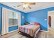 Bright bedroom featuring blue walls, ceiling fan and large window with natural light at 1205 Magnolia Hill Rd, Garner, NC 27529