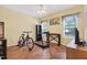 Bedroom with hardwood floors, exercise equipment, ceiling fan, and natural light from large windows at 1205 Magnolia Hill Rd, Garner, NC 27529