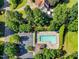 A high angle view of a community pool surrounded by lounge chairs and lush green trees at 1205 Magnolia Hill Rd, Garner, NC 27529