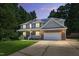 Inviting two-story home with a brick and siding exterior, solar panels, and attached two-car garage during dusk at 1205 Magnolia Hill Rd, Garner, NC 27529