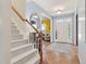 Bright foyer with herringbone wood flooring, stairs and entrance to living room with yellow accent wall at 1205 Magnolia Hill Rd, Garner, NC 27529