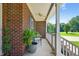 Relaxing front porch featuring brick columns, wooden railings, a ceiling fan and outdoor seating at 1205 Magnolia Hill Rd, Garner, NC 27529