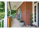 Cozy front porch with brick accents, wooden railings, and views of the surrounding greenery at 1205 Magnolia Hill Rd, Garner, NC 27529