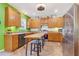 Modern kitchen with stainless steel appliances, wooden cabinets, island with seating, and hardwood floors at 1205 Magnolia Hill Rd, Garner, NC 27529