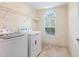 Bright laundry room with a washer, dryer, and arched window, offering functionality at 1205 Magnolia Hill Rd, Garner, NC 27529
