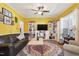 Bright living room with yellow walls, ceiling fan, herringbone floors, and comfortable seating at 1205 Magnolia Hill Rd, Garner, NC 27529
