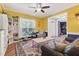 Open living room featuring yellow walls, herringbone floors, ample natural light, and cozy furnishings at 1205 Magnolia Hill Rd, Garner, NC 27529