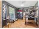 A well-lit office with custom shelving, herringbone floors, and a large window with views at 1205 Magnolia Hill Rd, Garner, NC 27529