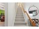 Stairway with wood railing, leading to the upper level of the home, adorned with a decorative mirror at 1205 Magnolia Hill Rd, Garner, NC 27529
