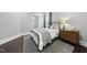 This bedroom boasts a metal-framed bed, a wood dresser, hardwood floors, and neutral-colored walls at 129 Damsire Way, Cary, NC 27513