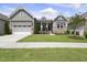 Charming home featuring a well-manicured lawn, a two-car garage and a welcoming front porch at 129 Damsire Way, Cary, NC 27513