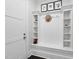 Mudroom with white built-in bench and storage shelves and hooks at 129 Damsire Way, Cary, NC 27513