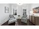 Stylish sitting room featuring comfortable chairs, dark hardwood floors and natural light at 129 Damsire Way, Cary, NC 27513