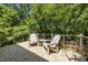 A wooden balcony overlooking a lush green yard, complete with outdoor furniture at 1317 Fay St, Durham, NC 27701
