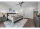 Primary bedroom boasts hardwood floors, ceiling fan, and a view of ensuite bathroom entrance at 1317 Fay St, Durham, NC 27701
