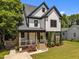 Stunning two-story modern farmhouse with black trim, welcoming front porch and manicured lawn at 1317 Fay St, Durham, NC 27701