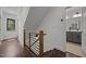 Hallway features hardwood floors, a staircase, and entry to bathroom with modern fixtures at 1317 Fay St, Durham, NC 27701