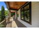 Charming covered porch featuring wood ceiling, metal railing, and sleek black-framed windows at 1317 Fay St, Durham, NC 27701