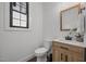 Clean powder room with wood vanity, modern fixtures, and natural light at 1317 Fay St, Durham, NC 27701
