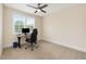 Well-lit bedroom featuring a window, ceiling fan, carpet, and a desk with a computer setup at 1344 Legend Oaks Dr, Chapel Hill, NC 27517
