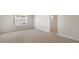 Bright bedroom featuring a window view, neutral carpet, and an ensuite bathroom at 136 Pisgah St, Sanford, NC 27330