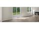 Bright living room featuring wood floors, a window, and sliding glass doors to the backyard at 136 Pisgah St, Sanford, NC 27330